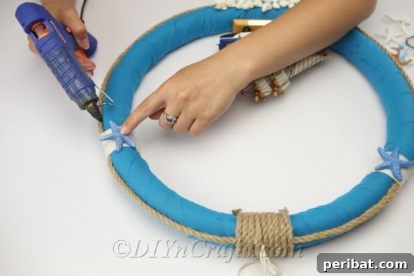 Coastal Elegance: Craft Your Perfect Summer Wreath 25 Carefully glue additional nautical embellishments, like starfish or anchors, to your wreath.