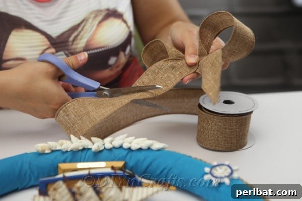 Coastal Elegance: Craft Your Perfect Summer Wreath 26 Cut a strip of rustic ribbon, preparing it to be tied into a decorative bow.