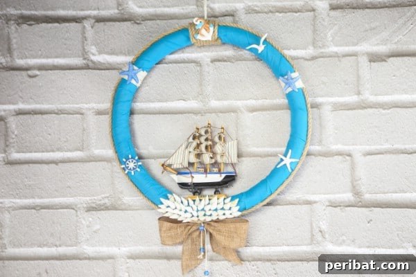 A vibrant nautical wreath featuring a small boat, shells, and blue fabric, perfect for summer home decor.