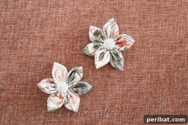 Two completed fabric flowers, showcasing their intricate details and craftsmanship, displayed side by side.