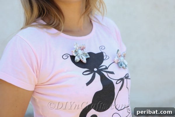 A close-up view of two handmade fabric flowers gracing a t-shirt, perfect for adding a touch of personalized flair.