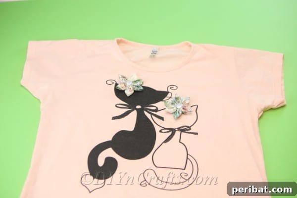 Two vibrant handmade fabric flowers elegantly placed on a light-colored shirt, showcasing their versatile decorative potential.