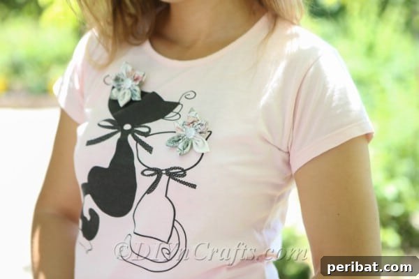 Showcasing two fabric flowers pinned onto a t-shirt, illustrating their potential as unique fashion accessories.