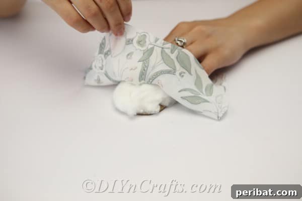 Clever Pincushion Jar Sewing Caddy 10 Layering the materials: place cotton stuffing on the cardboard circle, then gently lay the chosen fabric on top, ready for assembly.