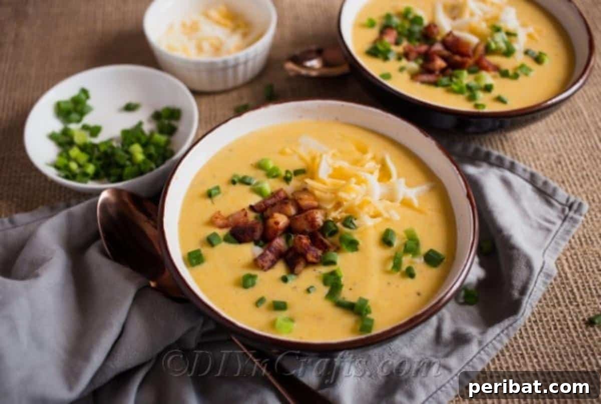 Heartwarming Cheesy Potato Comfort Soup 3 Cheesy Potato Soup garnished with a generous amount of shredded cheddar, crispy crumbled bacon, and fresh diced green onions, ready for serving.