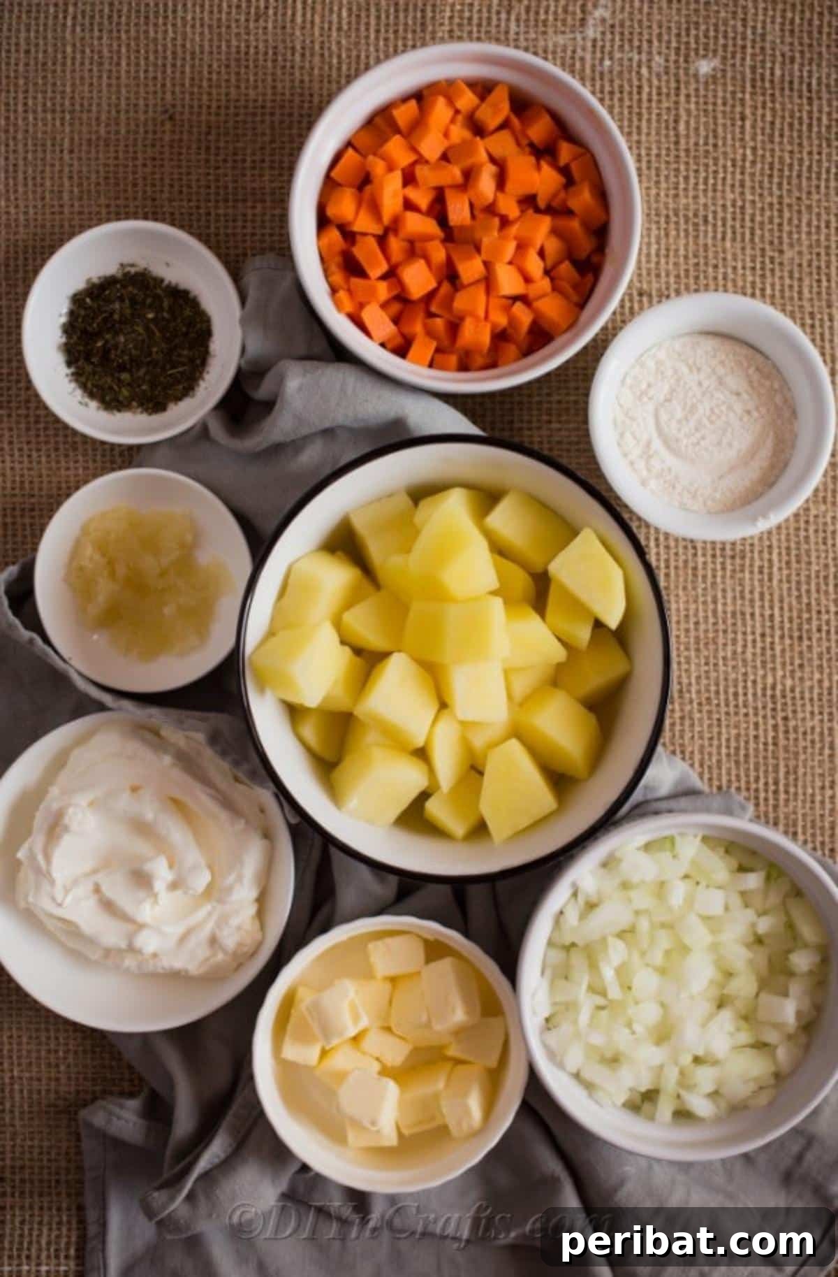 Heartwarming Cheesy Potato Comfort Soup 7 A vibrant display of fresh ingredients for potato soup laid out in white bowls on a rustic wooden table, including potatoes, carrots, onions, and herbs.