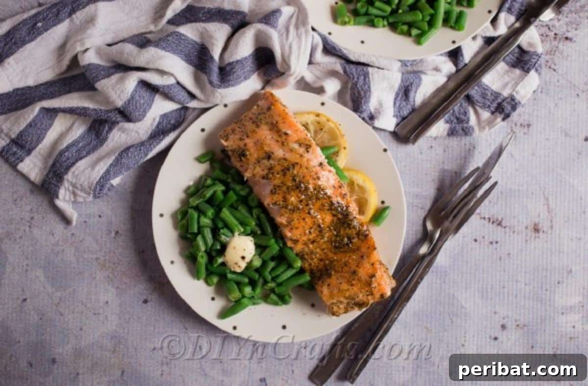 Perfectly Glazed Honey Garlic Salmon 5 Overhead picture of a piece of honey baked salmon on a white plate with gray napkin in background