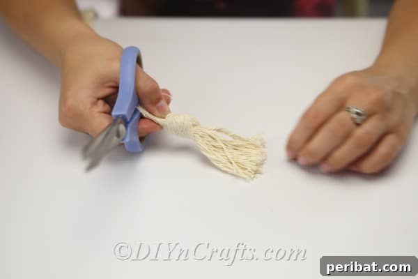The cords have been tied together with an overhand knot, forming the base of the hanging mechanism.