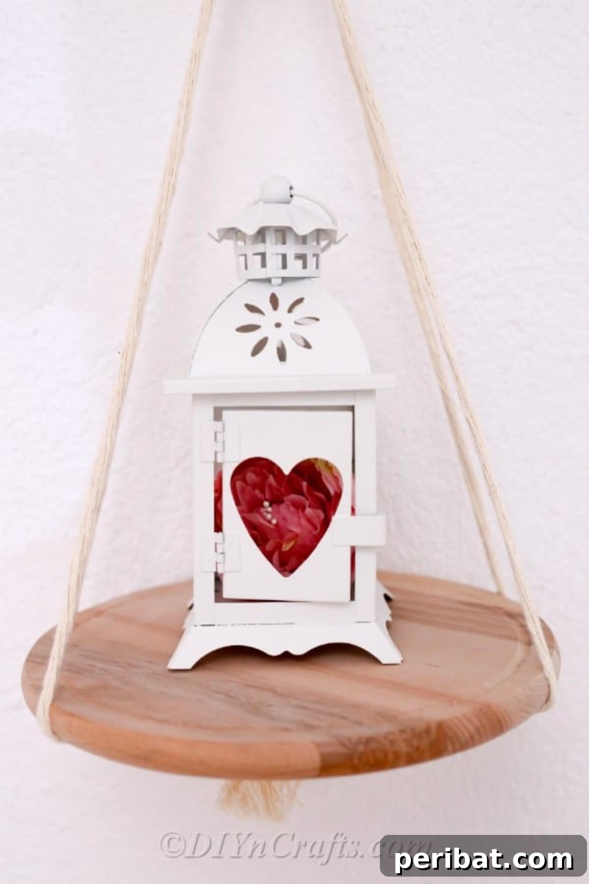Make Your Own Decorative Hanging Shelf 3 A minimalist hanging shelf against a pristine white wall, elegantly holding a small lamp and decorative elements, highlighting its decorative potential.
