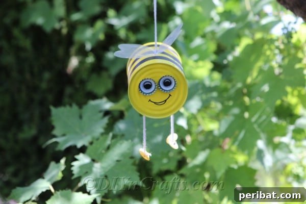 Tin can bee craft hanging from a tree
