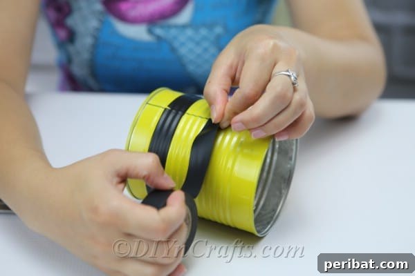 DIY Whimsical Hanging Garden Bees 14 A picture showing a woman threading twine through holes to create legs on bee craft