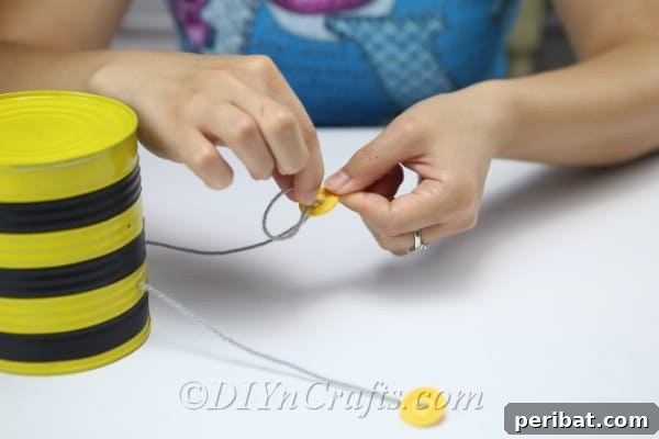 Adding buttons to the thread used for legs on the bee craft