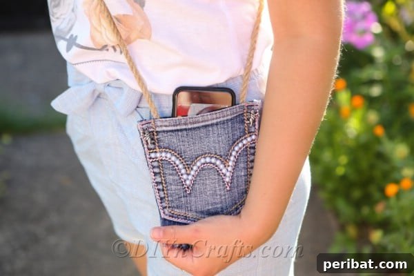 Craft Your Own Chic Denim Bag 22 Woman proudly carrying her DIY denim bag across her shoulder, with a phone peeking out from the top pocket.