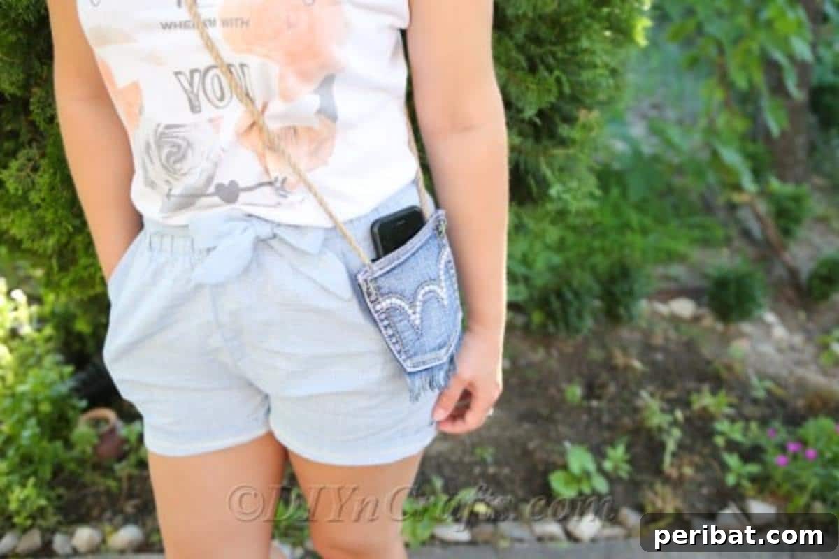 Craft Your Own Chic Denim Bag 5 Close-up of a woman in a garden, proudly displaying her denim bag with a phone neatly tucked into its repurposed pocket.