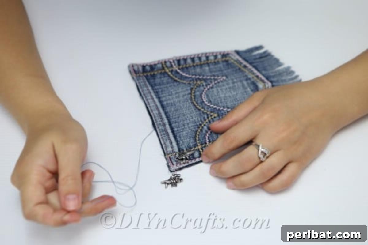 Craft Your Own Chic Denim Bag 10 Close-up demonstrating the process of cutting a fringe along the bottom edge of the denim pocket for the bag.