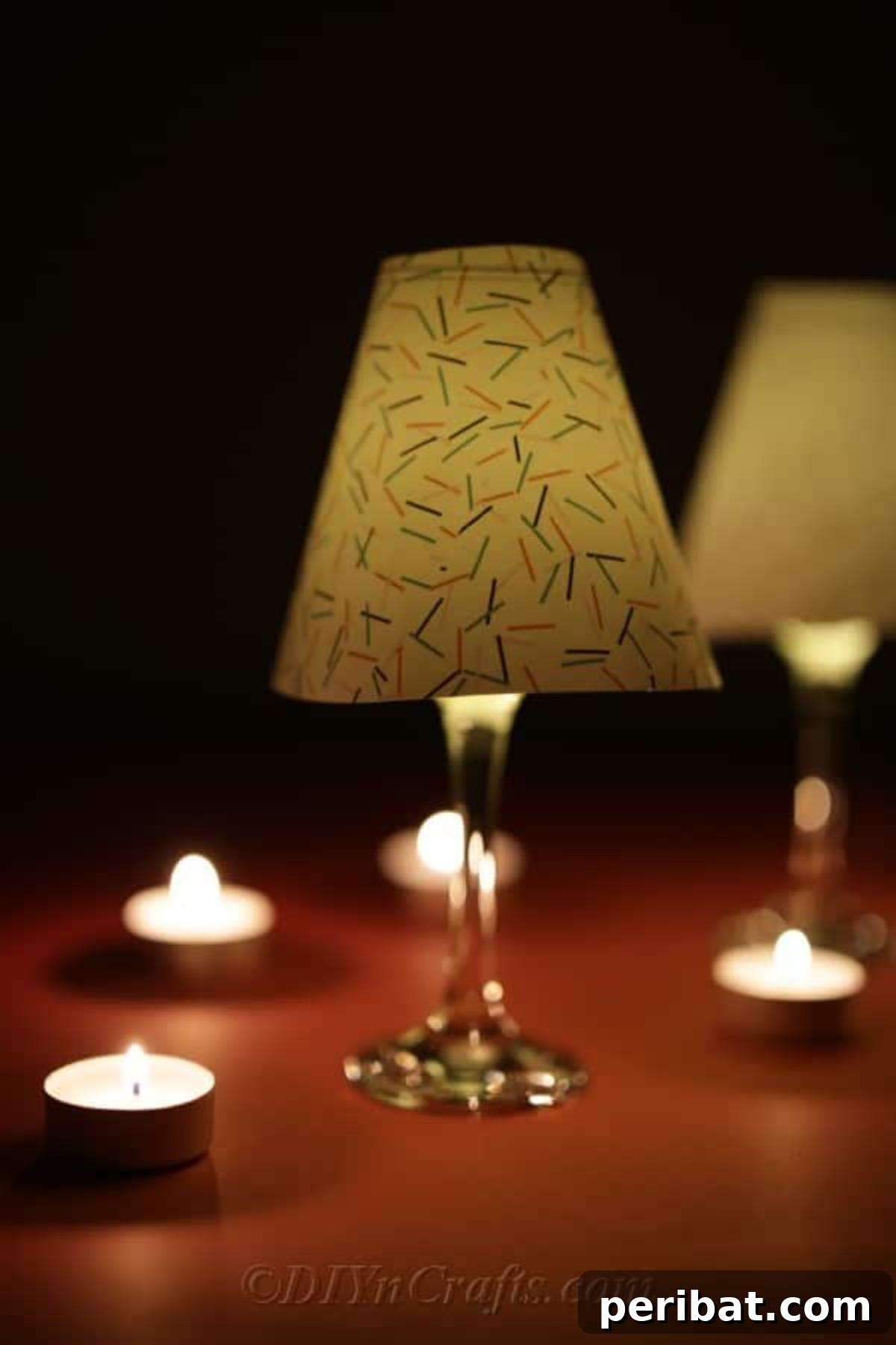 Upcycled Wine Glass Tealight Lanterns 11 A completed wine glass lantern sitting on a table in the dark to showcase the glow of candle light
