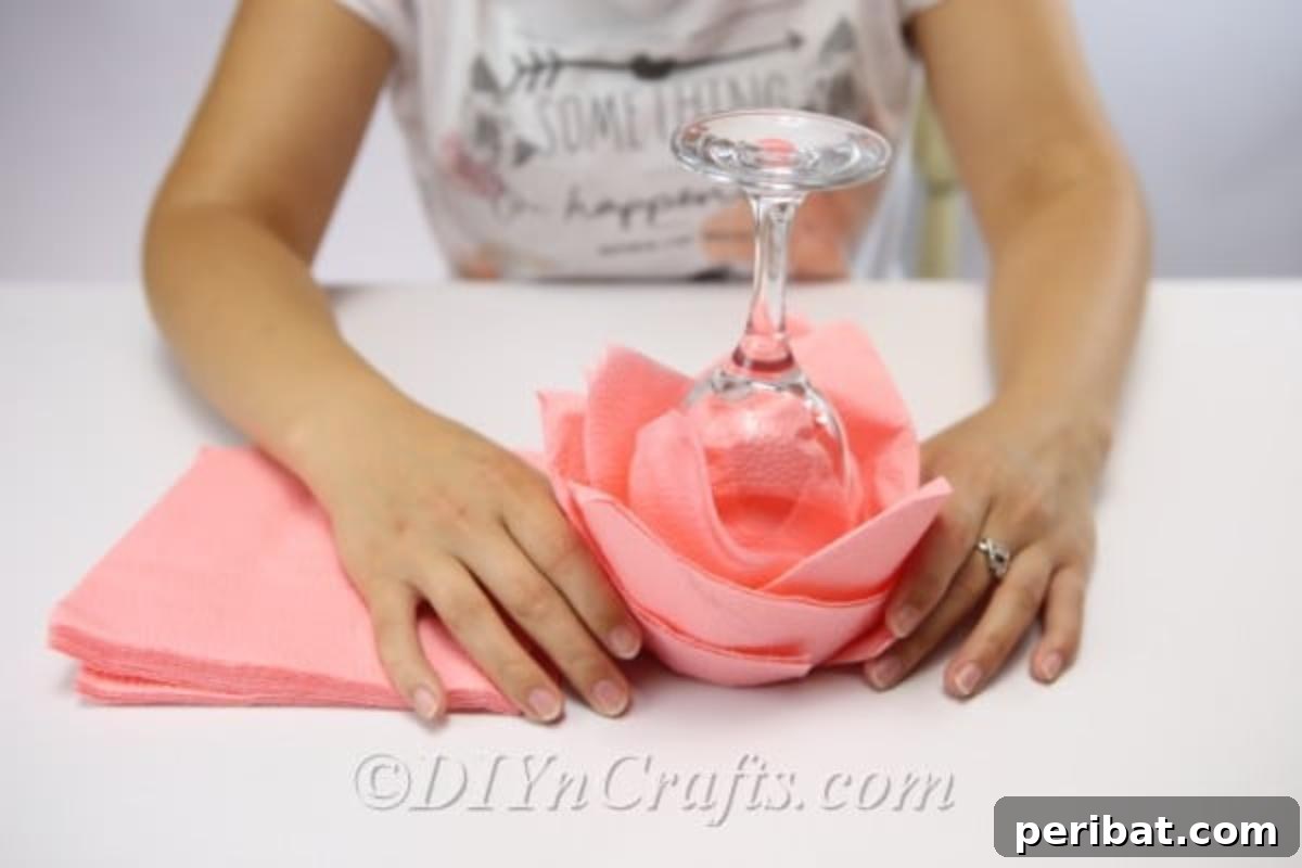 Fold Beautiful Napkin Roses 8 Carefully removing the paper napkin rose from the glass for display on a plate or table