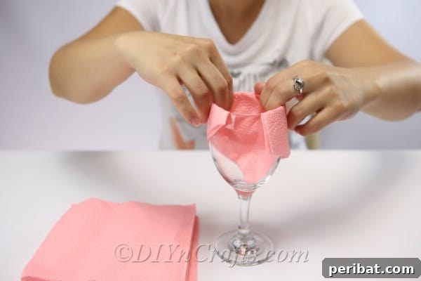 Fold Beautiful Napkin Roses 10 Folding a paper napkin over the top of a win glass when learning how to fold napkins