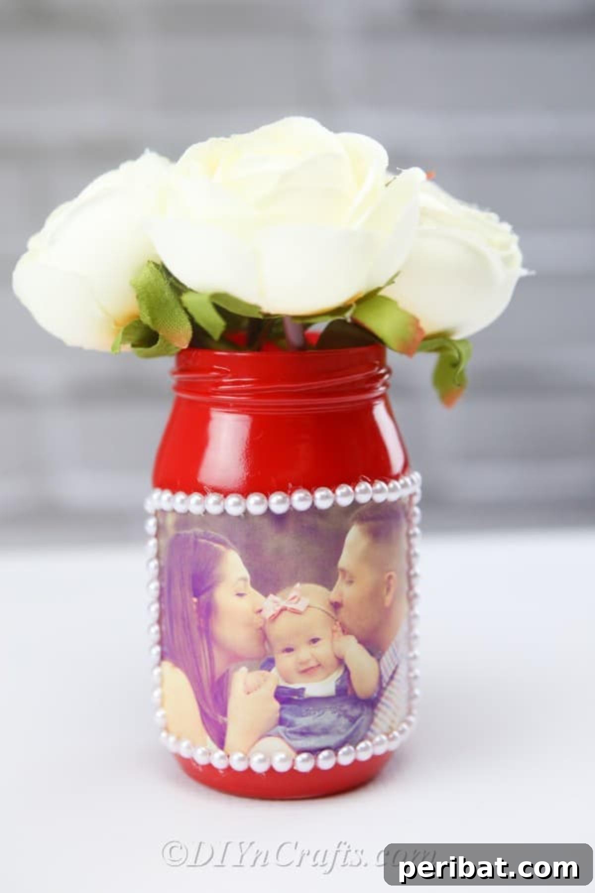 Create Stunning Photo Vases with Your Memories 2 A handmade photo jar vase featuring a family photo displayed with a wall in the background.