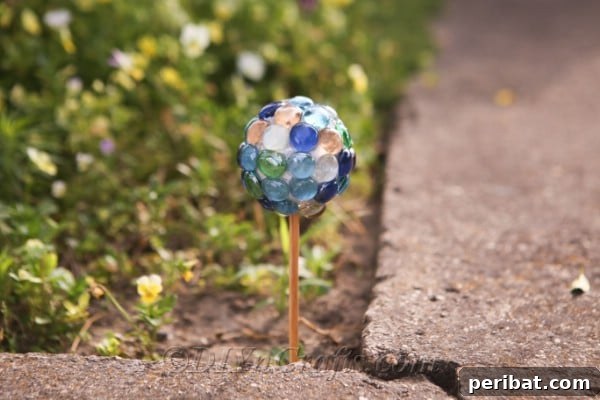 Craft Your Own Garden Spheres 10 A finished DIY lawn ornament sparkling next to a garden path.