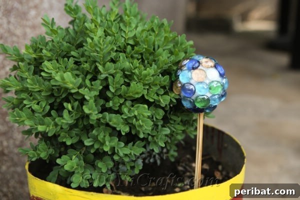 Craft Your Own Garden Spheres 11 A DIY lawn ball ornament thoughtfully placed within a decorative planter.