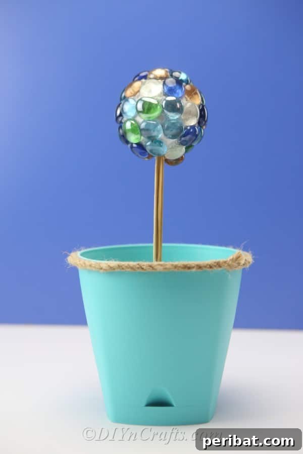 Craft Your Own Garden Spheres 13 A sparkling DIY ball decoration enhancing a planter arrangement.