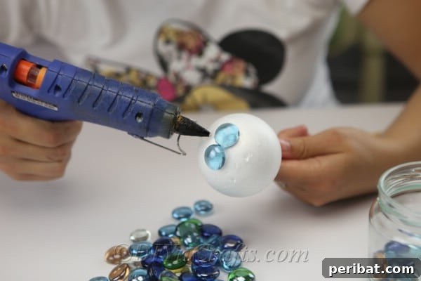 Craft Your Own Garden Spheres 8 Continue gluing glass nuggets, ensuring full coverage and minimizing gaps.
