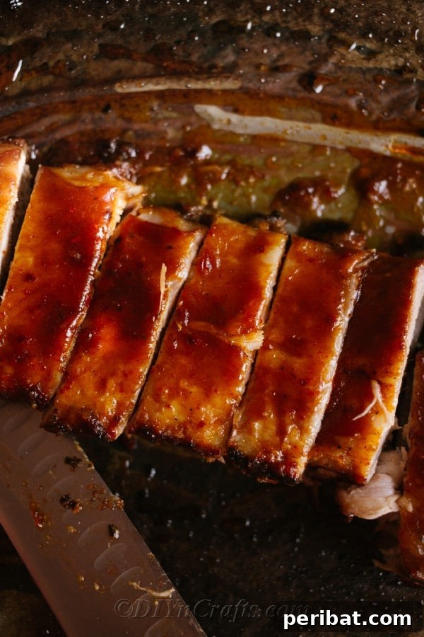 Effortless Fall-Off-The-Bone Oven Ribs 13 Baking sheet covered with delicious BBQ oven baked ribs, sliced and perfectly glazed, ready to be served