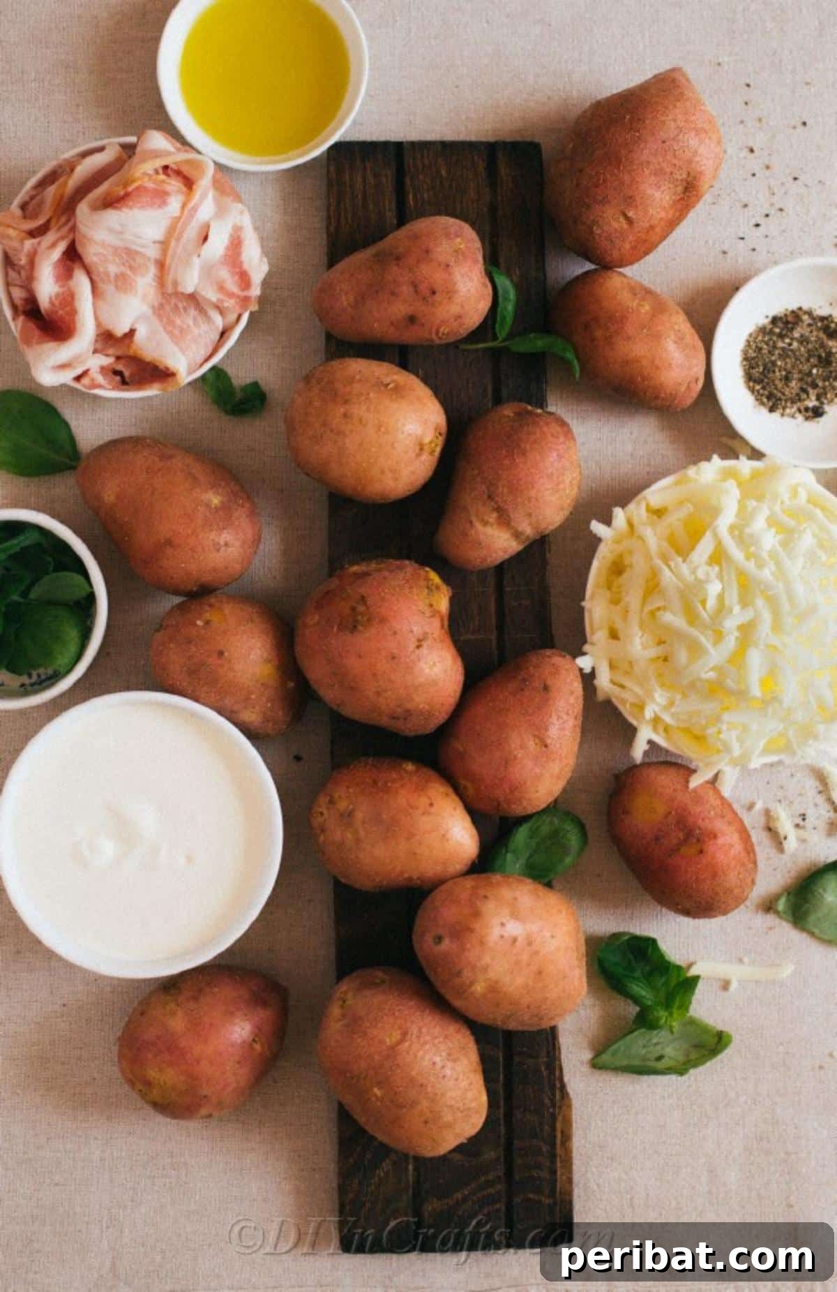 Simple Fully Loaded Potato Skins 7 A beautifully arranged flat lay of fresh ingredients for loaded potato skins, including whole potatoes, a bowl of shredded cheese, cooked bacon, sour cream, and fresh basil, all neatly presented on a rustic wooden table.