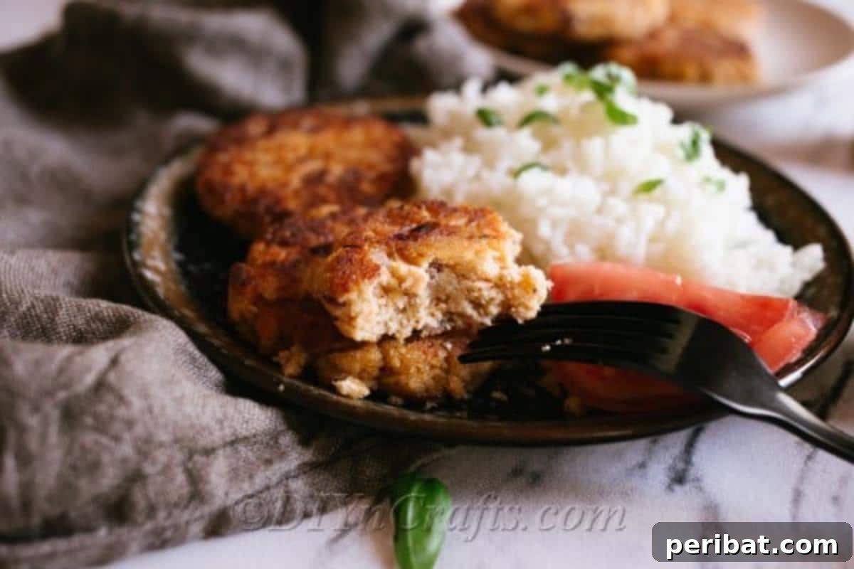 An up close image of a plate of an easy salmon patty recipe with rice and vegetables