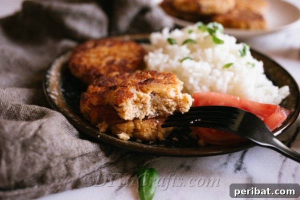 An up close image of a plate of an easy salmon patty recipe with rice and vegetables