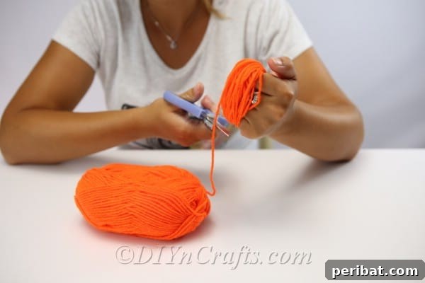 Handmade Autumn Yarn Pumpkin Garland Tutorial 14 Cutting the end of the yarn pumpkin for the diy fall decor garland