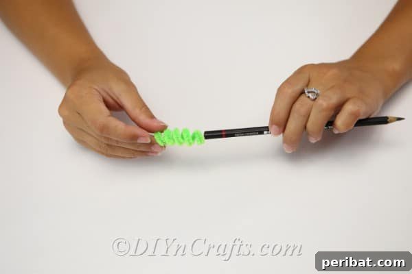 Handmade Autumn Yarn Pumpkin Garland Tutorial 17 Creating a stem for the yarn pumpkin by wrapping a pipe cleaner around a pencil