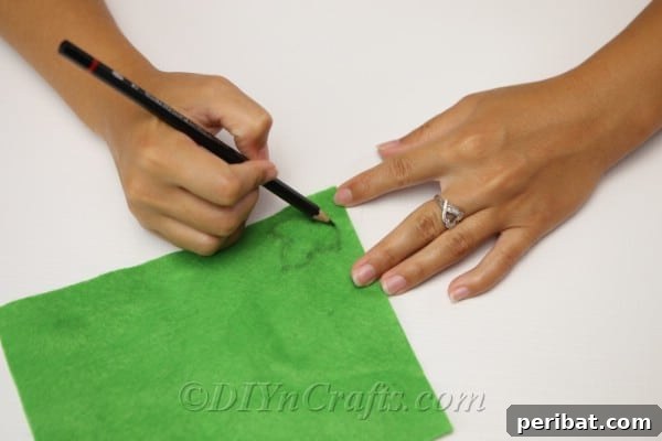 Handmade Autumn Yarn Pumpkin Garland Tutorial 18 Drawing leaves on the green felt to create leaves for the yarn pumpkin that goes on the diy all decor garland