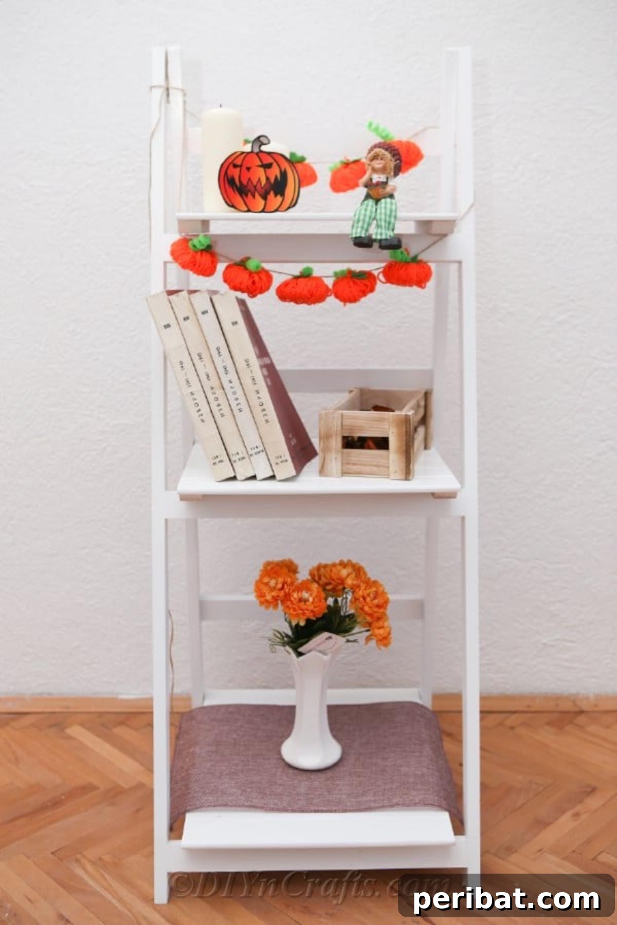Handmade Autumn Yarn Pumpkin Garland Tutorial 4 Yarn pumpkin garland displayed inside on a white shelf