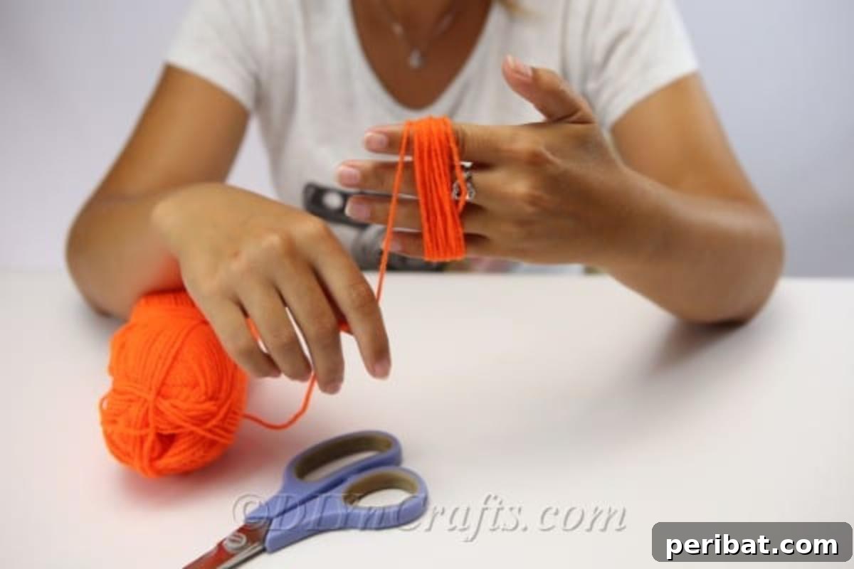 Handmade Autumn Yarn Pumpkin Garland Tutorial 7 A woman making a circle of yarn around her hand to create a yarn pumpkin for the diy falll decor garland