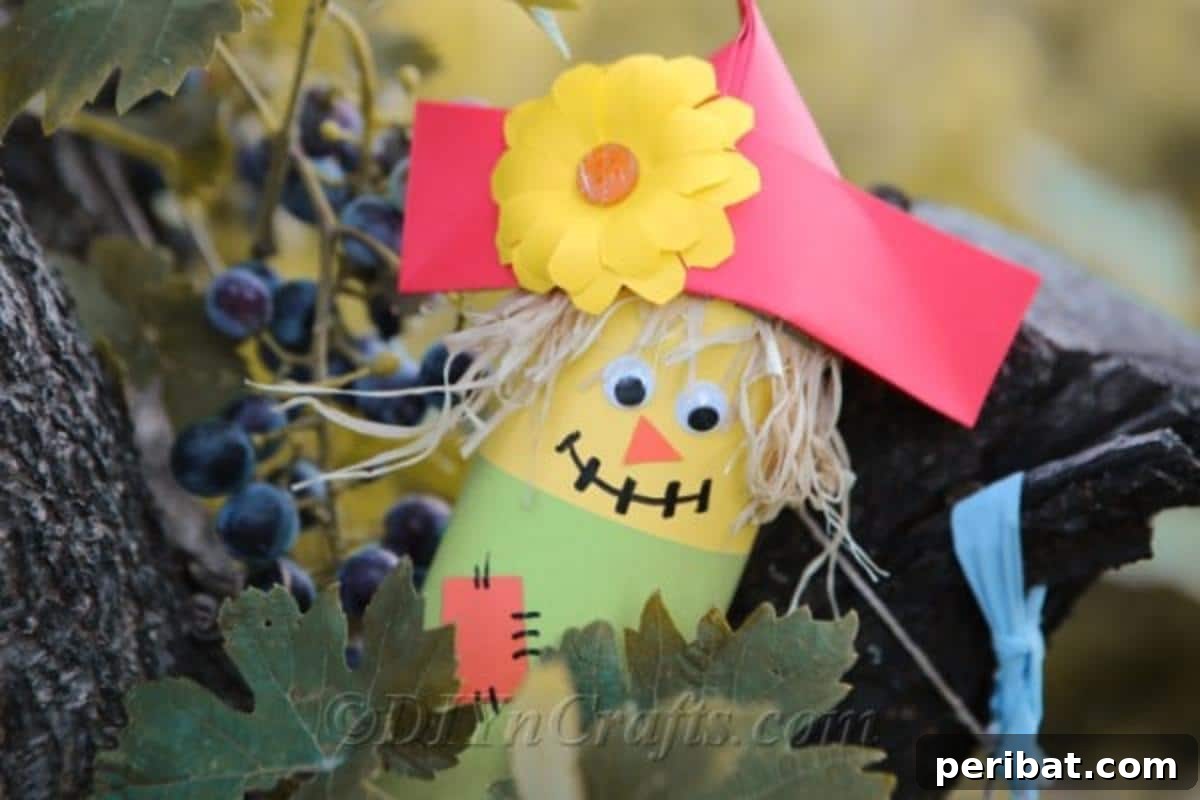 Paper scarecrow craft sitting outside in a grape vine