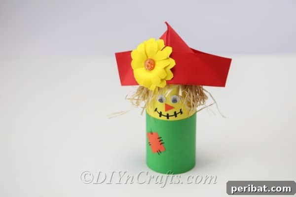 Completed scarecrow craft sitting on a white table