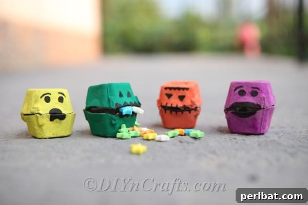 Decorated Halloween monster treat boxes lined up on a table, showcasing various designs and embellishments