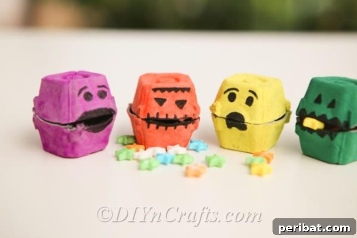 Line of colorful Halloween monster treat boxes with small candies in front