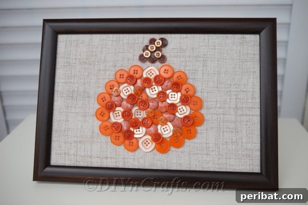 The final pumpkin button art fall decor piece resting elegantly on a white counter, ready to enhance your home