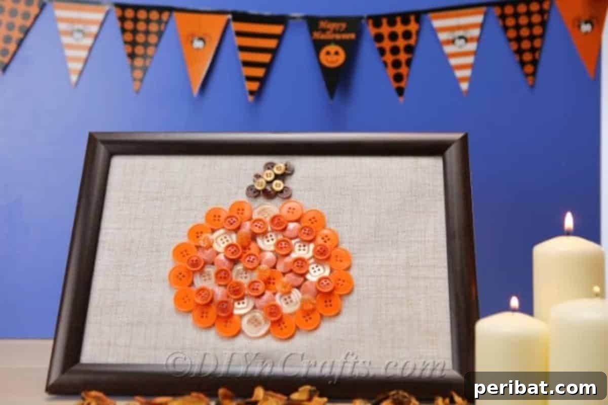 A beautifully finished pumpkin button art piece showcased in front of a black and white bunting, with a soft blue background, creating a charming display