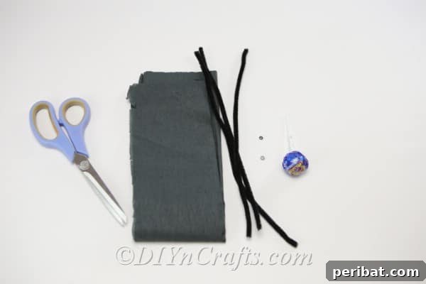 A neatly organized collection of supplies for making spider lollipops for Halloween.