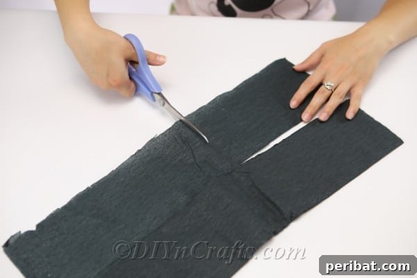 Measuring and cutting black tissue paper into squares for the spider lollipop craft.