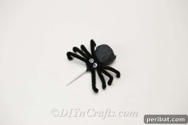 A completed spider lollipop standing upright, ready for display.