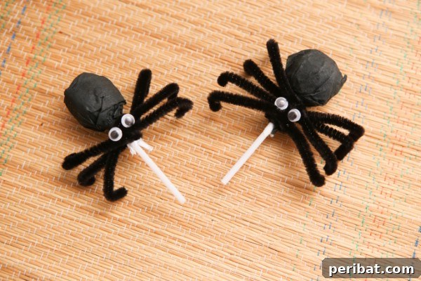 How to Make Adorable Spider Lollipops for Halloween - A finished spider lollipop with festive background.