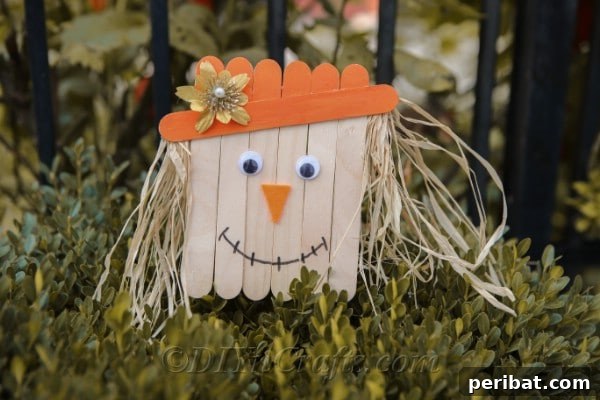 A finished scarecrow head sitting on a shrub outside against a black fence
