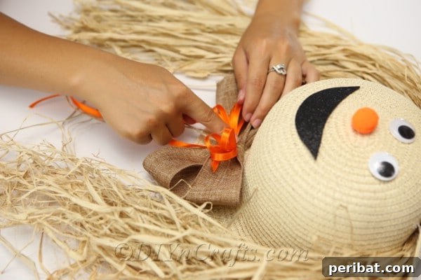 Securing the bow onto the front of the scarecrow lady face