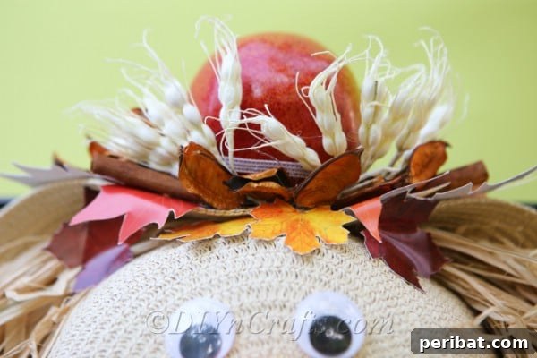 Finished lady scarecrow harvest decor with an apple on top as a hat