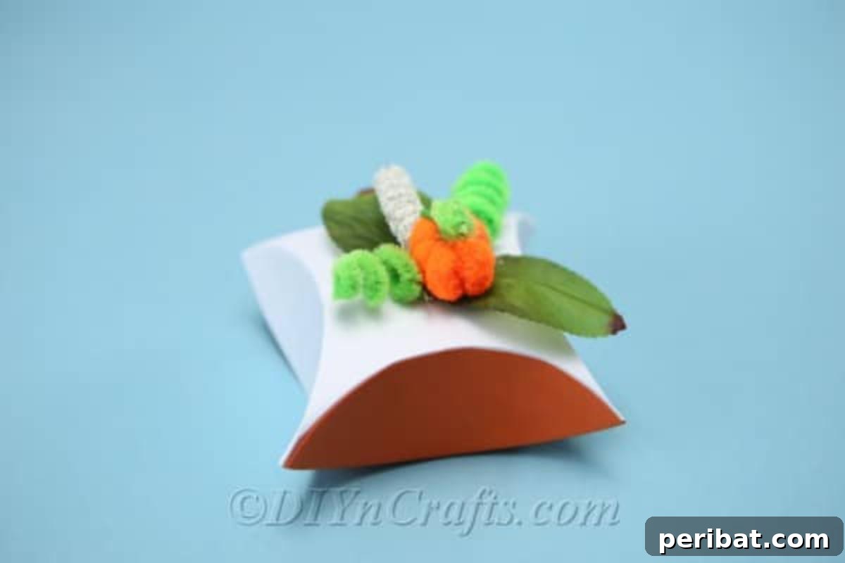 Craft Charming Pumpkin Gift Boxes 3 Completed pumpkin DIY gift box sitting on a vibrant blue surface